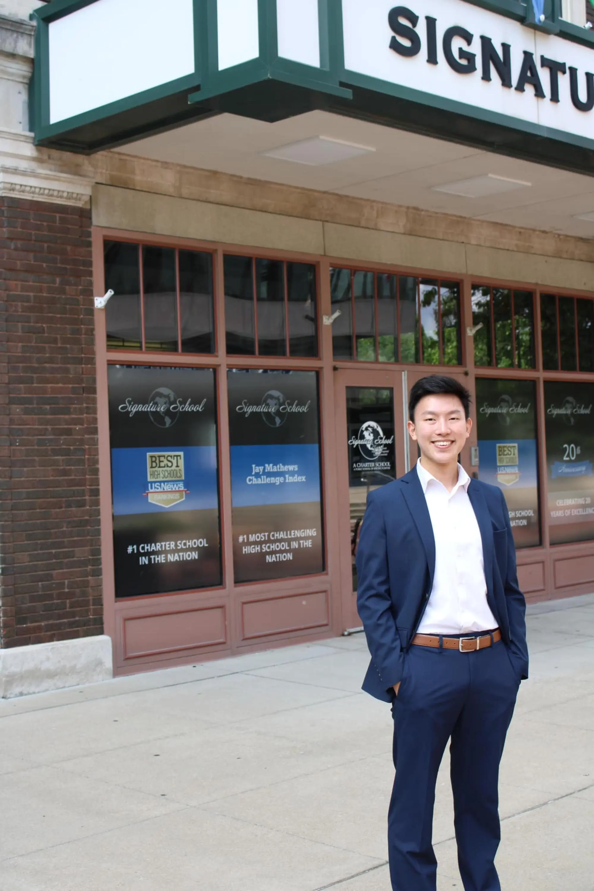 Student standing outside entrance in suit