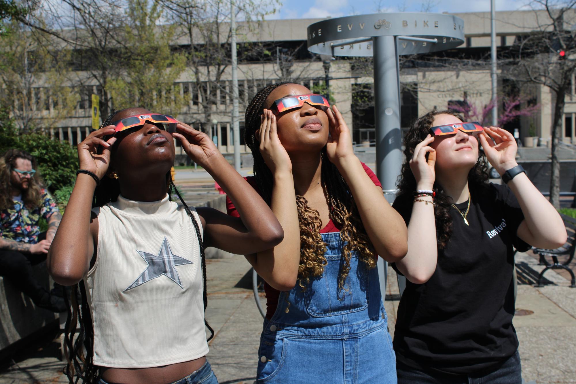 Students looking at sun with eclipse glasses