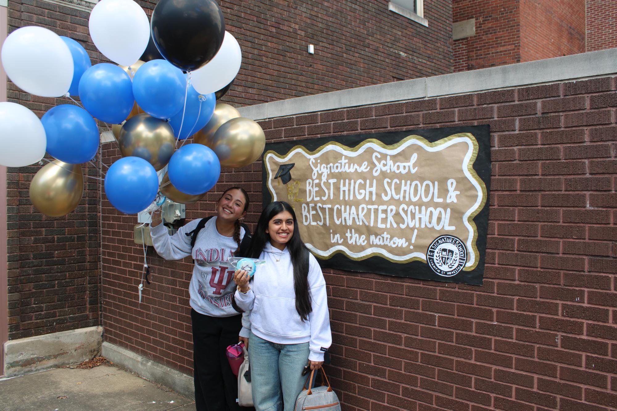 girls smiling holding balloons and cookies